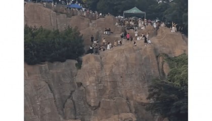 大连一跨海大桥观景台有游客翻栏杆踩空心造景石拍照,当地回应